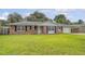 Charming brick home with green lawn, black shutters and attached carport at 113 Jackson Rd, Ladson, SC 29456