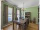 Elegant dining room with a chandelier, wooden table, and two large windows at 1213 Grasswind Dr, Hanahan, SC 29410