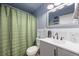 Well-lit bathroom with a modern vanity, stylish mirror, and a shower with a green curtain at 124 Englewood Rd, Goose Creek, SC 29445