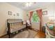 Bedroom with a dark iron crib, wooden floors, and natural light streaming through the window at 124 Englewood Rd, Goose Creek, SC 29445