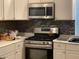 Well-equipped kitchen with stainless steel appliances and sleek gray backsplash at 1969 Comstock Ave, North Charleston, SC 29405