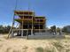 Exterior shot of a multi-story home under construction on a sandy lot with scaffolding at 2879 Marshall Blvd, Sullivans Island, SC 29482