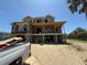 Under construction; two story home on sandy lot with windows and a porch framed with unfinished wood at 2879 Marshall Blvd, Sullivans Island, SC 29482