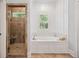 Bright bathroom with tile shower, soaking tub with white paneled surround, and natural light from windows at 2911 Old Tavern Ct, Mount Pleasant, SC 29466