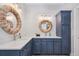 Elegant bathroom featuring a double vanity, stylish blue cabinets, quartz countertop and unique woven-texture mirrors at 2911 Old Tavern Ct, Mount Pleasant, SC 29466