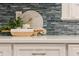 Close-up of quartz countertop with tile backsplash, plus cutting board, plant, and rolling pin at 2911 Old Tavern Ct, Mount Pleasant, SC 29466