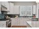 Bright kitchen features stainless appliances, white cabinets, tile backsplash, and quartz countertops at 2911 Old Tavern Ct, Mount Pleasant, SC 29466