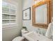 Well-lit powder room featuring a framed mirror and elegant fixtures at 2911 Old Tavern Ct, Mount Pleasant, SC 29466