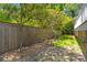 Fenced backyard area with stone pavers, trees, and a small grass area at 3 Sand Dollar Dr, Isle of Palms, SC 29451