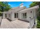 Backyard view of a white home with a deck and lush greenery at 3 Sand Dollar Dr, Isle of Palms, SC 29451