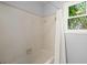 Bathroom with a white tiled shower/tub combination and a window for natural light at 3 Sand Dollar Dr, Isle of Palms, SC 29451