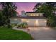 Inviting home exterior with a two-car garage, well-maintained landscaping, and charming curb appeal during twilight at 3 Sand Dollar Dr, Isle of Palms, SC 29451