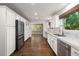 Updated kitchen featuring white cabinets, marble countertops, stainless steel appliances, and hardwood floors at 3 Sand Dollar Dr, Isle of Palms, SC 29451