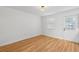 Bright, empty room with hardwood floors, a window with blinds, and a door to the exterior at 415 Parkdale Drive # E-8, Charleston, SC 29414