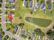 An aerial view shows the property, backyard with white fencing, and pond in the community at 4847 Cane Pole Ln, Summerville, SC 29485