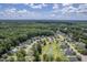 Aerial view showing community homes near mature trees, green spaces, and a pond at 4847 Cane Pole Ln, Summerville, SC 29485