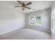 Cozy bedroom with ceiling fan, carpeted floor, and a window showcasing the beautiful backyard view at 4847 Cane Pole Ln, Summerville, SC 29485
