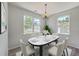 Sunlit dining room featuring a modern chandelier, two large windows, and seating for six at 4847 Cane Pole Ln, Summerville, SC 29485