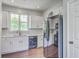 Modern kitchen featuring white cabinets, stainless steel appliances, wood floors and a bright window overlooking the backyard at 4847 Cane Pole Ln, Summerville, SC 29485