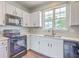 Updated kitchen with white cabinetry, new counters, modern appliances, and a window providing natural light at 4847 Cane Pole Ln, Summerville, SC 29485