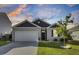 Charming single-story home with a two-car garage and a well-manicured lawn at sunset at 545 Wayton Cir, Moncks Corner, SC 29461