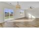 Bright living room with wood floors, sliding glass door to yard, modern light fixture and ceiling fan at 545 Wayton Cir, Moncks Corner, SC 29461