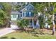 Beautiful two-story home with green exterior, inviting front porch, and lush landscaping at 794 Hunt Club Run, Charleston, SC 29414