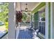 Relaxing covered front porch features chairs and hanging flower basket at 794 Hunt Club Run, Charleston, SC 29414