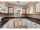 Cozy kitchen featuring white cabinetry, brown countertops, and a window overlooking the backyard at 8108 Halifax Way, North Charleston, SC 29420