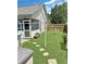 Landscaped backyard featuring a green lawn, patio, hammock, and fenced perimeter at 8496 Roanoke Dr, North Charleston, SC 29406