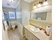 Bright bathroom with patterned wallpaper, vanity, sink, mirror, toilet, and tiled floor at 8496 Roanoke Dr, North Charleston, SC 29406