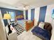 Comfortable bedroom with striped wall, wooden bed frame, loveseat, and black and white patterned rug at 8496 Roanoke Dr, North Charleston, SC 29406