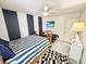 Cozy bedroom with a striped accent wall, television, ceiling fan, and a striped comforter at 8496 Roanoke Dr, North Charleston, SC 29406