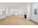 Open-concept living room featuring hardwood floors, a modern fireplace, and large windows with plenty of natural light at 9017 Stern Aly, Johns Island, SC 29455