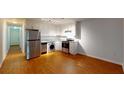 Galley kitchen boasting stainless steel appliances and wood flooring at 40 Bee St # 111, Charleston, SC 29403