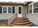 Side entrance with brick steps and white door at 8375 Shell House Rd, Edisto Island, SC 29438
