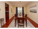 Formal dining room featuring hardwood floors, a wooden table, and dark blue curtains at 8897 Cat Tail Pond Rd, Summerville, SC 29485