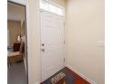 Front entry with white door, wood flooring, and view into adjacent room at 8897 Cat Tail Pond Rd, Summerville, SC 29485