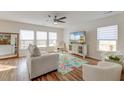 Bright living room with a large window, stylish furnishings, and hardwood floors under a decorative rug at 7034 Lanier St, Hanahan, SC 29410