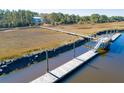 Stunning aerial view of a marsh landscape with a wooden dock leading to waterfront property at 1718 Vireo Ct, Johns Island, SC 29455