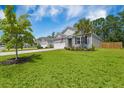 Single story home on a large manicured lawn and palm tree set under a blue sky at 360 Bering Ln, Summerville, SC 29486