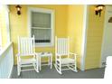 Front porch with rocking chairs and a view of the street at 2 Pelican Reach # Share 10, Isle of Palms, SC 29451