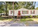 Charming single-story home featuring red shutters and landscaping near the entry at 2991 Blackfish Rd, Johns Island, SC 29455