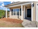 House entrance with black door, white columns, and pine straw at 1112 Moss Grove Dr, Moncks Corner, SC 29461