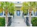 Front entry with white stairs, black railings, and lush landscaping at 2972 Anchor Watch Dr, Wadmalaw Island, SC 29487