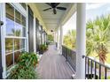 Spacious front porch with white columns, gray flooring, and hanging planter at 2972 Anchor Watch Dr, Wadmalaw Island, SC 29487