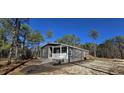 Gray manufactured home with front porch and steps, situated on a wooded lot at 392 Dike Rd, Bonneau, SC 29431