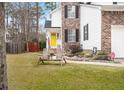 Landscaped yard with wooden chairs and a walkway to the front door at 1005 Shinnecock Hills Ct, Summerville, SC 29483