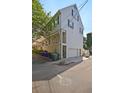 Side view of townhome showcasing white exterior, green shutters, and a garage at 15 Horlbeck Aly # A-7, Charleston, SC 29401