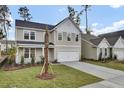 Two-story house with gray siding, white garage door, and palm tree in front at 2018 Quiet Ibis Rd, Hanahan, SC 29410